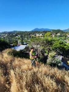 Land surveying in an open field overlooking a valley in CA